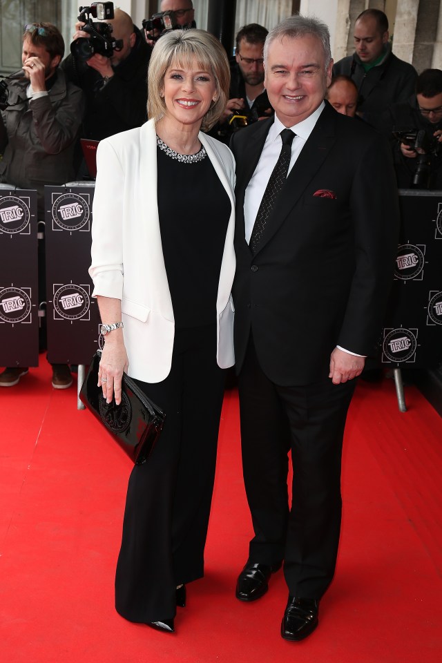 a man and a woman are standing on a red carpet with a sign that says ' bbc ' on it