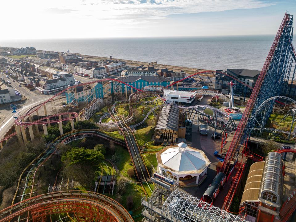 an aerial view of an amusement park with roller coasters and a ferris wheel