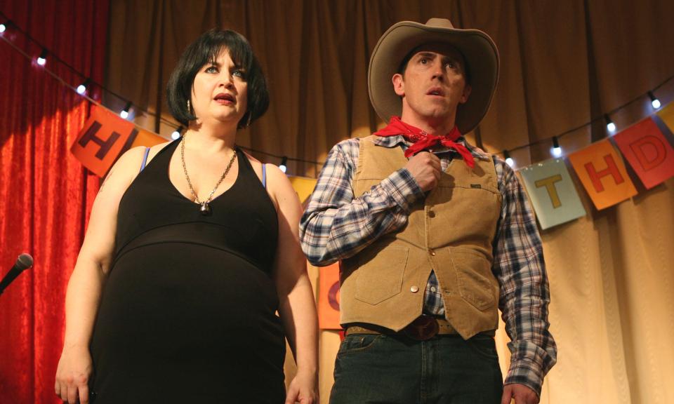 a man in a cowboy hat stands next to a woman in a black dress