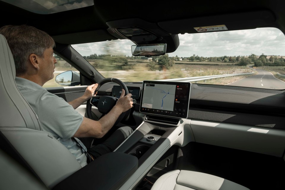a man is driving a car with a map on the dashboard