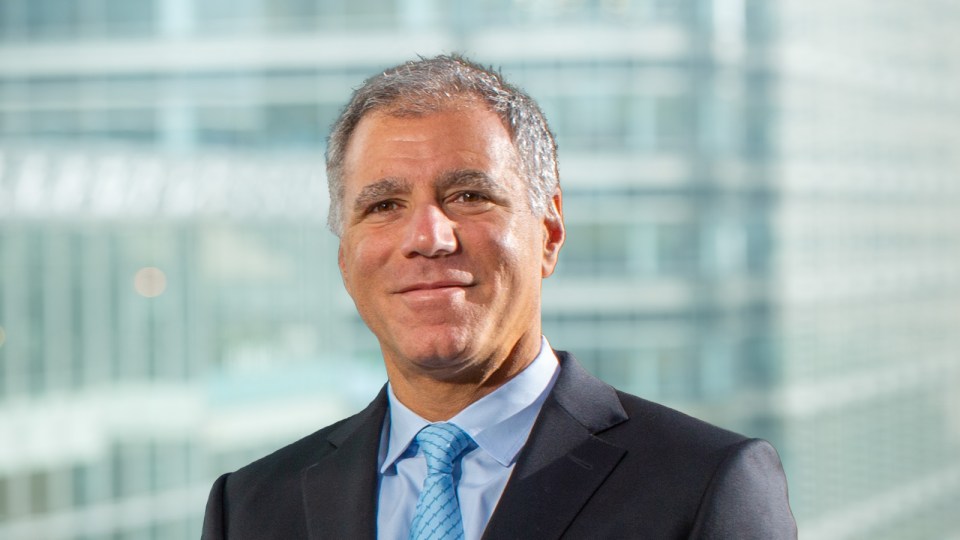 a man in a suit and tie stands in front of a window