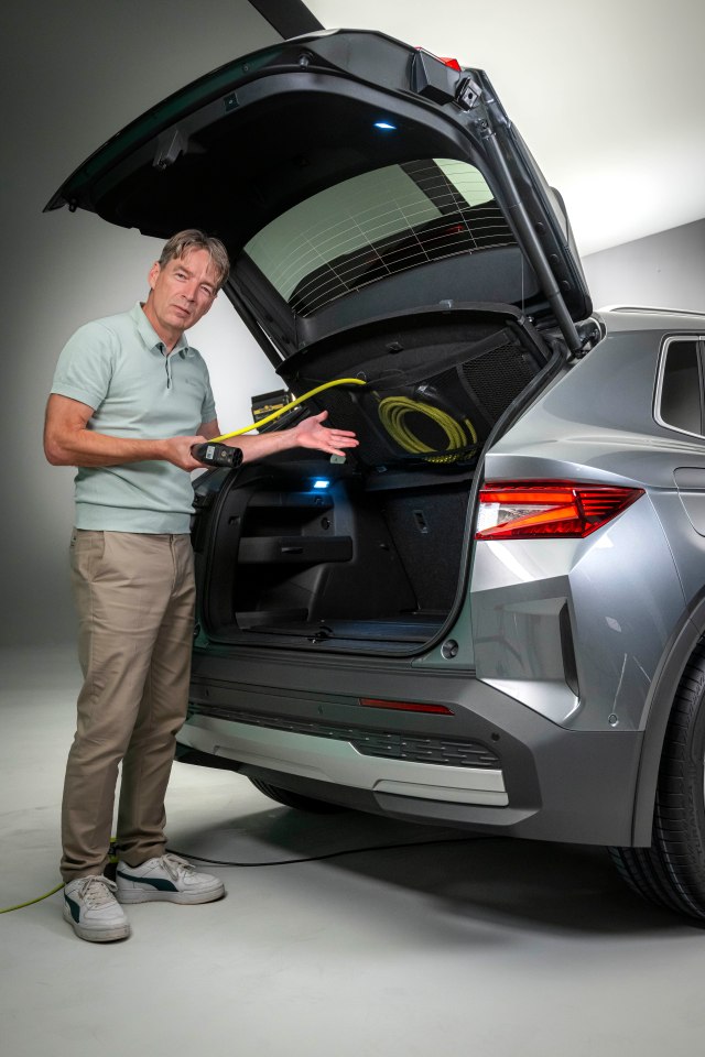 a man standing next to a car with the trunk open