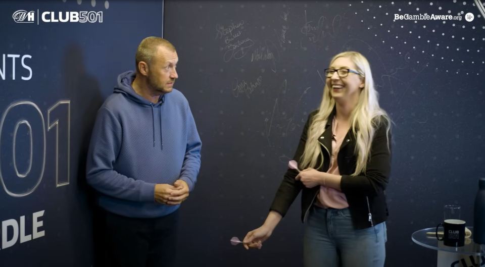 a man and a woman are standing in front of a wall that says club 501