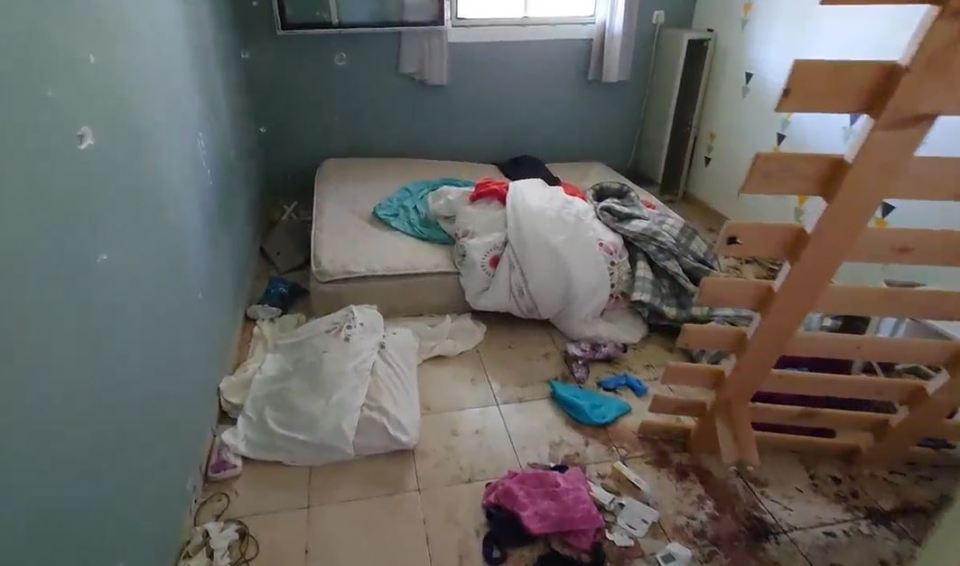 a messy room with a mattress and clothes on the floor