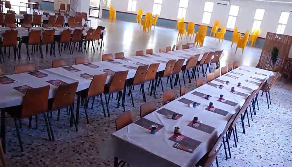 a long dining room with tables and chairs set up for a banquet