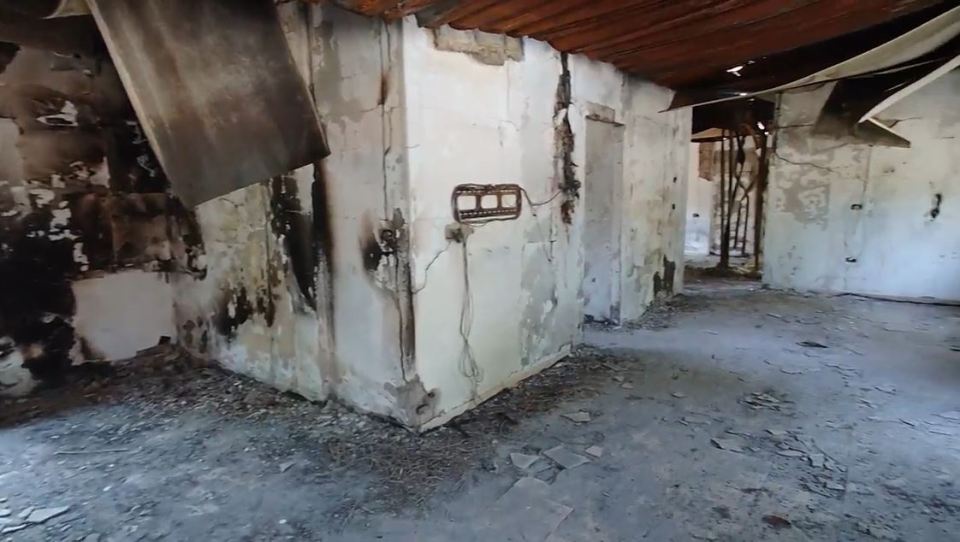 a corner of an abandoned building with a broken wall