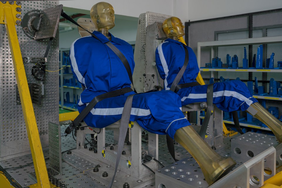 two mannequins wearing blue overalls are sitting on a table