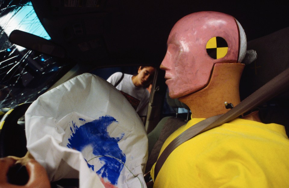 a mannequin wearing a pink head with a yellow caution sign on it