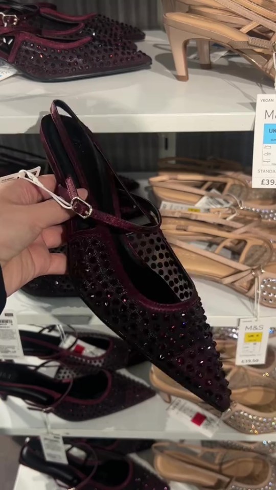a person is holding a pair of shoes with a tag that says m & s on it