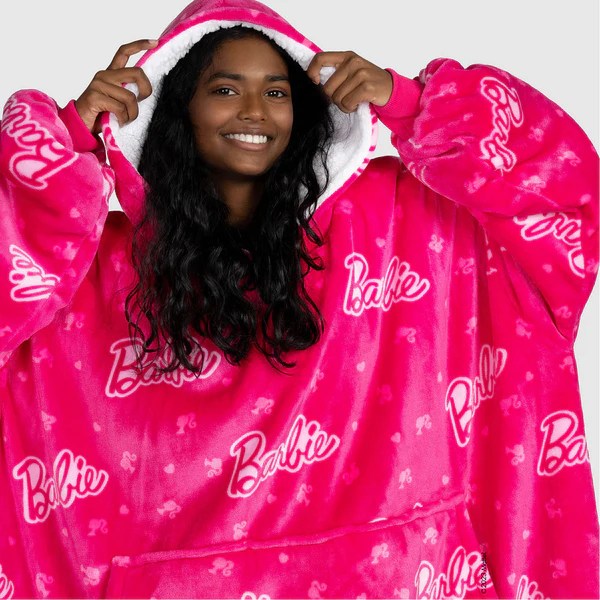 a woman wearing a pink blanket with the word barbie on it