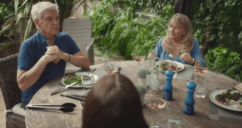 a man and woman sit at a table with plates of food