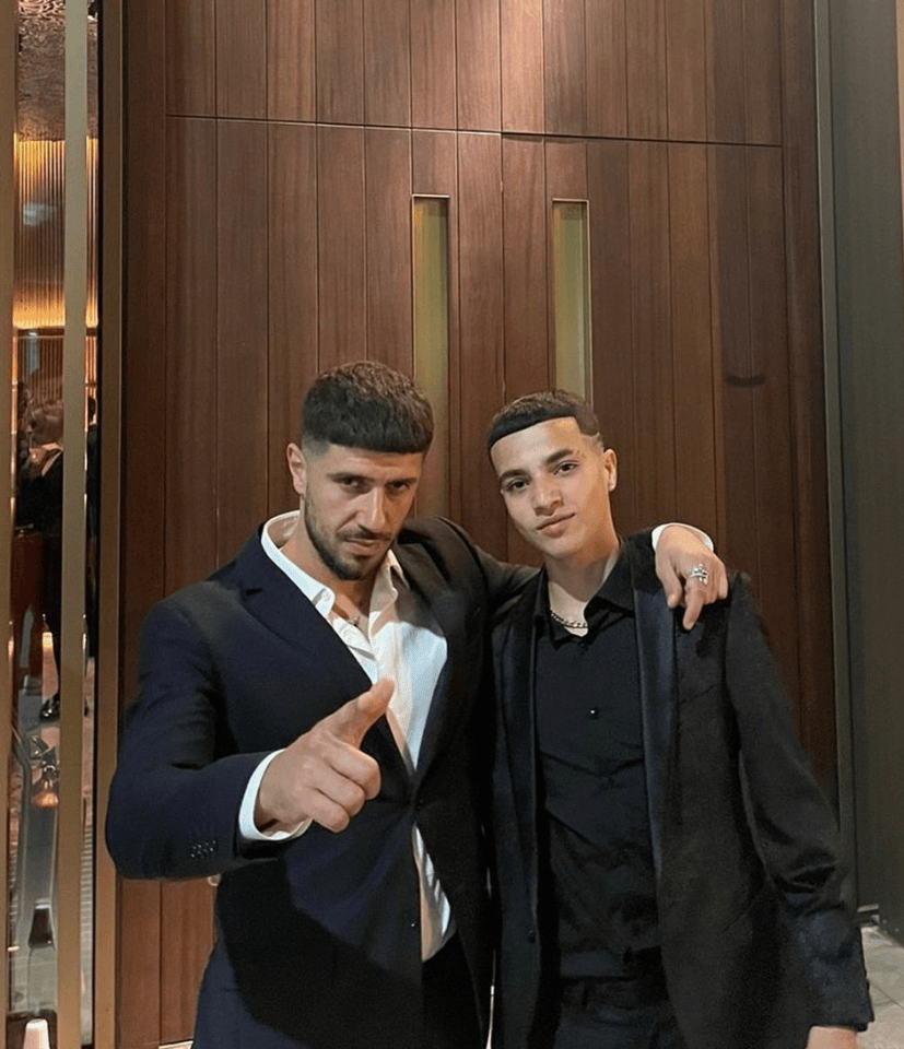 two men are posing for a picture and one has a ring on his finger
