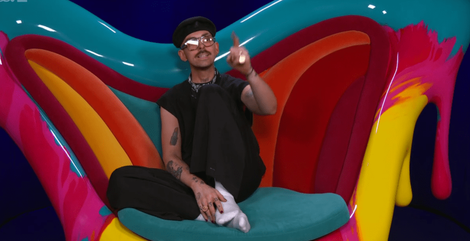a man sits on a colorful chair with his feet crossed