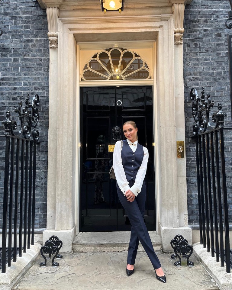 a woman stands in front of the number 10 door