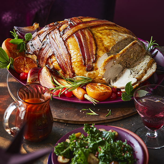 a turkey wrapped in bacon is on a plate with vegetables
