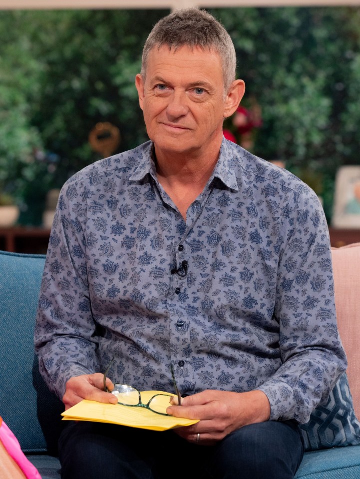 a man in a blue shirt is sitting on a couch