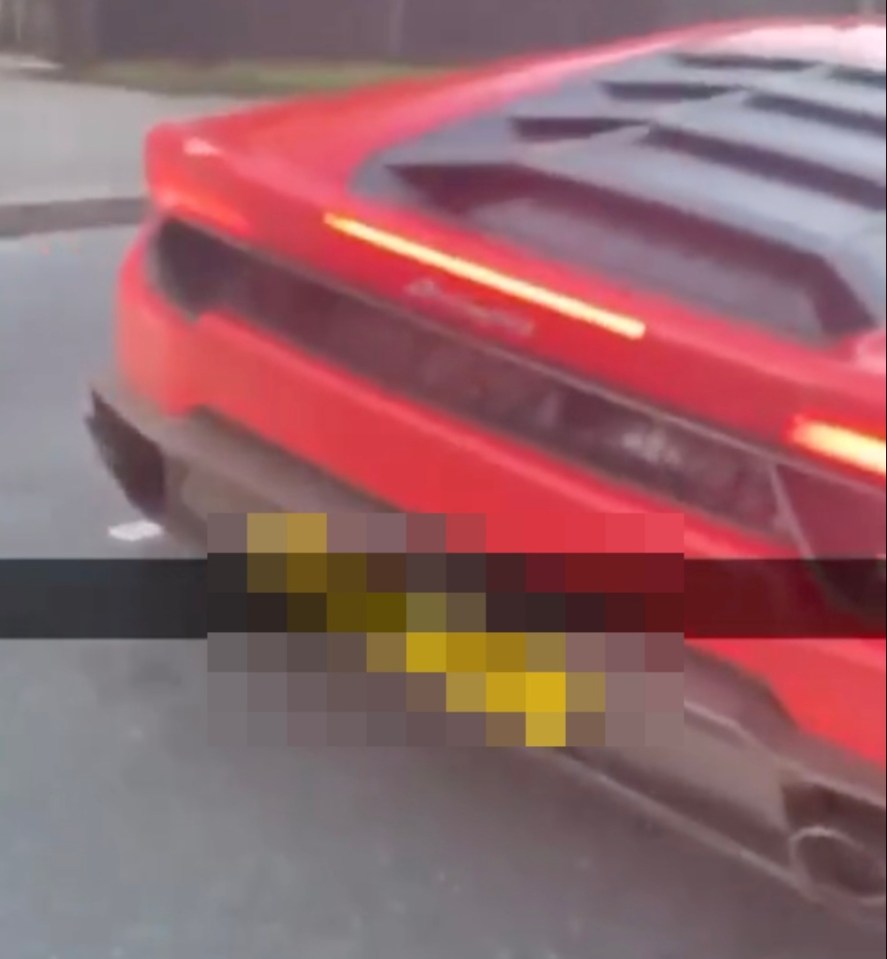a red sports car is driving down a street with a yellow license plate