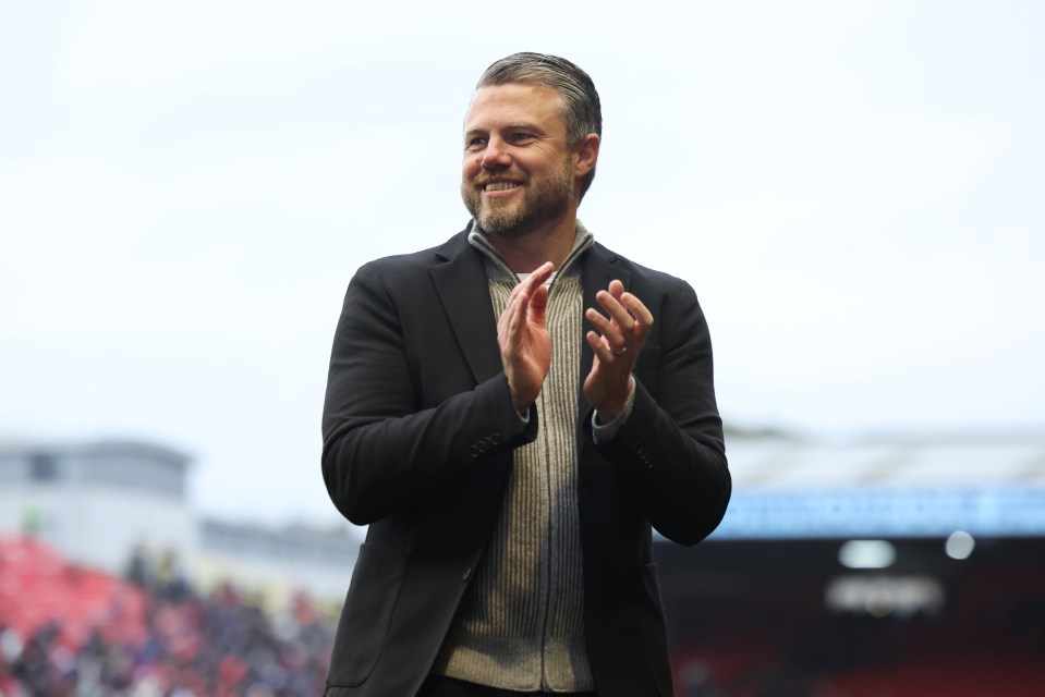 a man in a suit and sweater is clapping his hands