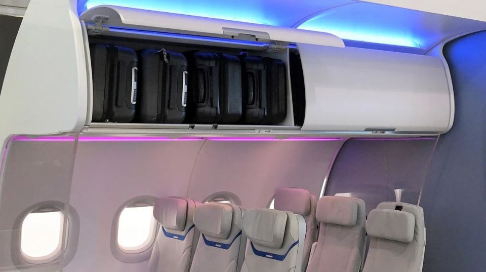 a row of seats on an airplane with luggage in the overhead compartment