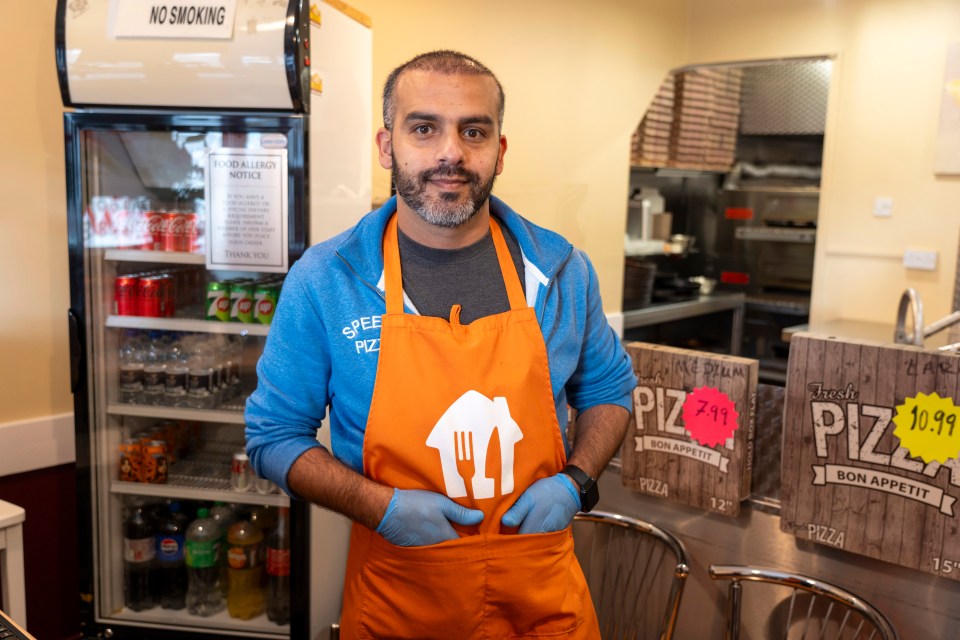 a man wearing an apron that says pizza on it