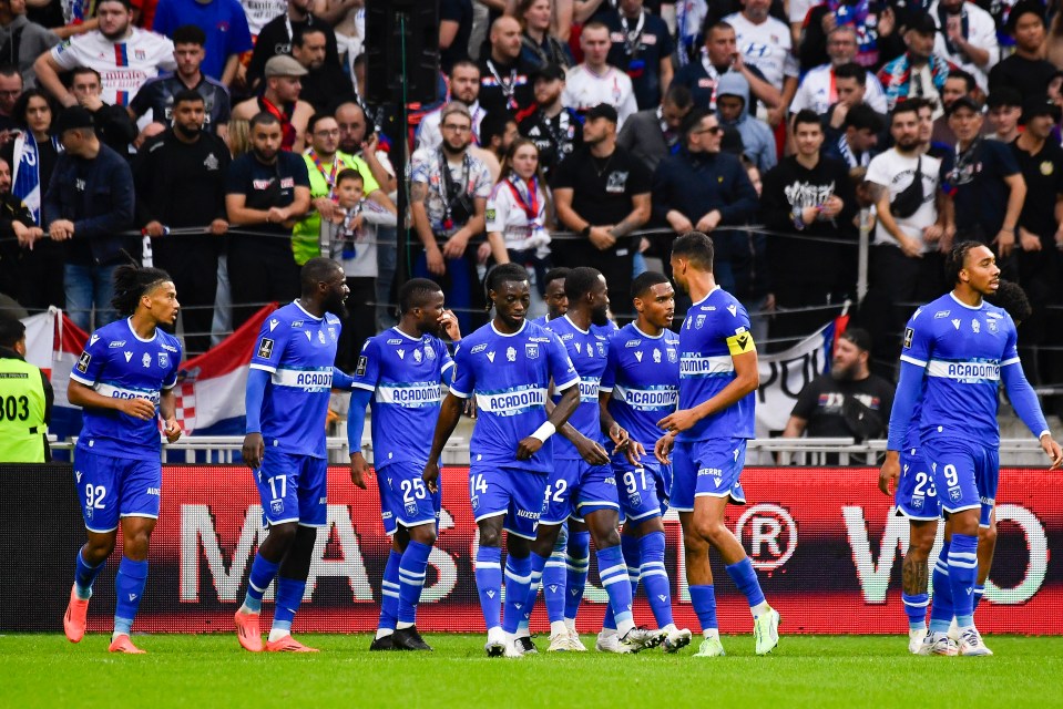 a group of soccer players are standing on a field wearing jerseys that say acropolis