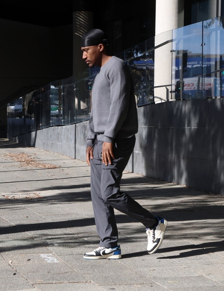 a man wearing a headband walks down a sidewalk