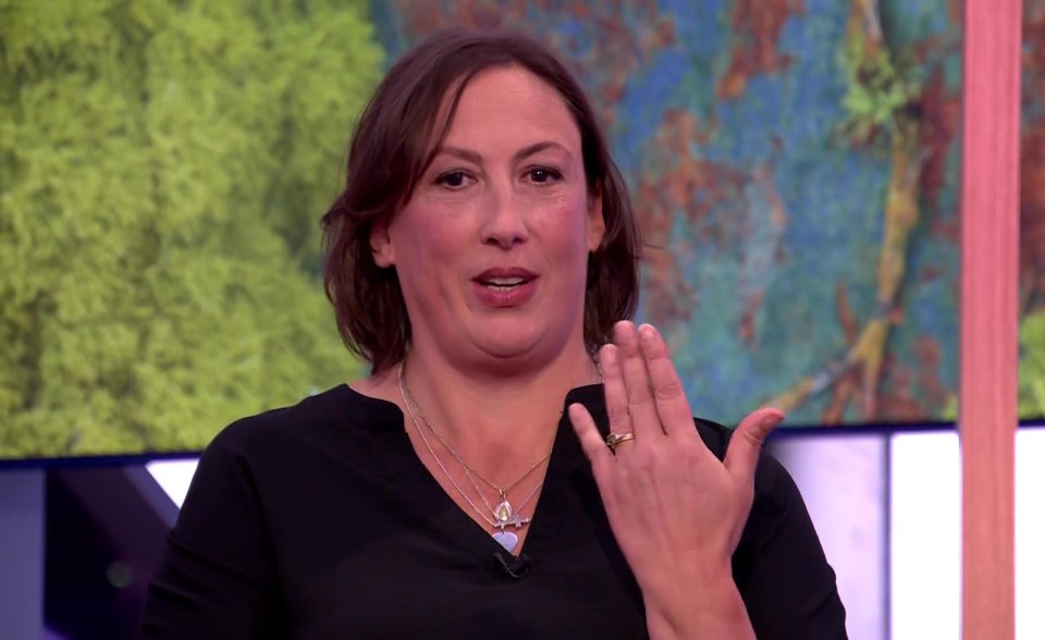 a woman wearing a black shirt and a gold ring on her finger