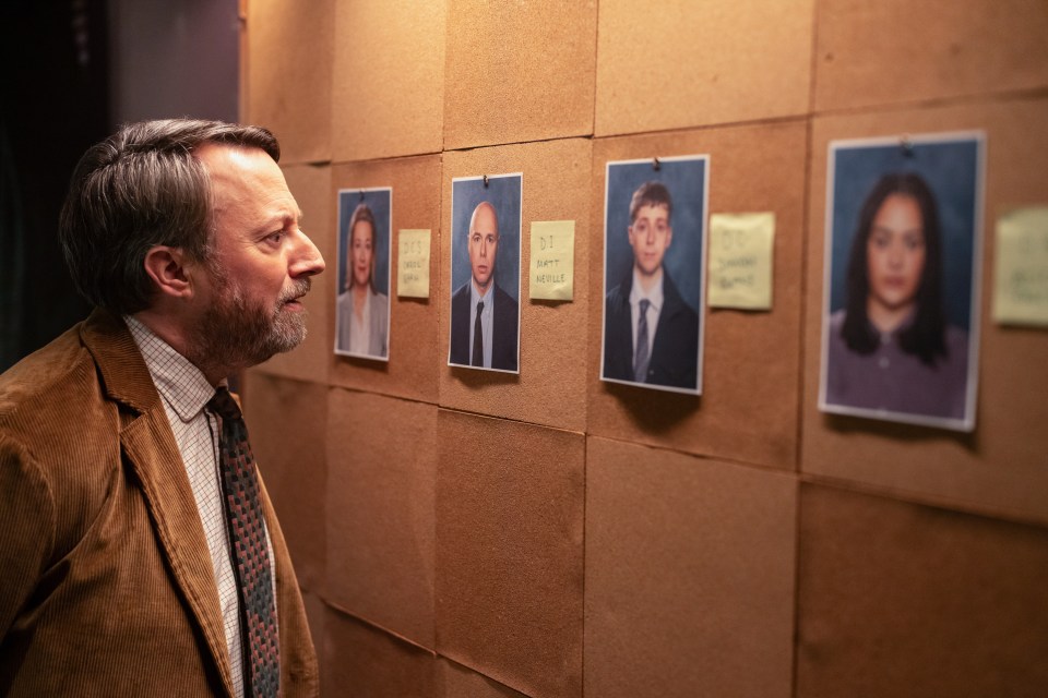 a man looking at a bulletin board with a picture of a man and a woman on it