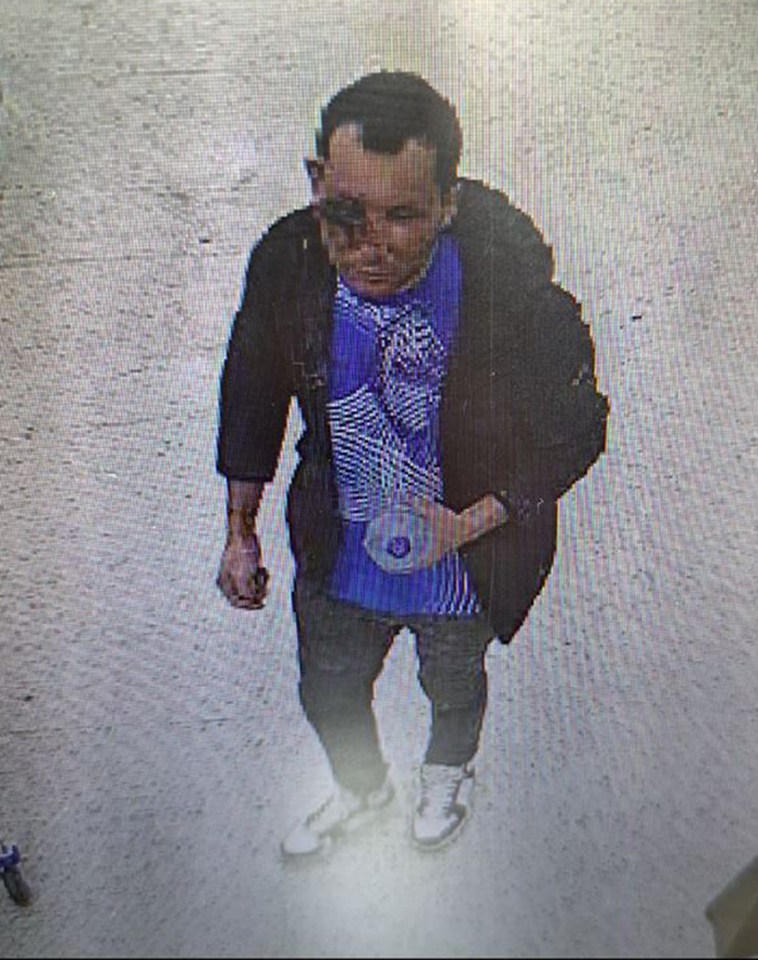 a man wearing a black jacket and a blue shirt is walking down the street