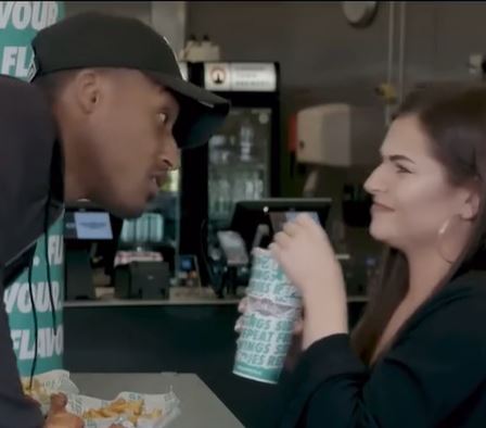 a man and a woman are sitting at a table in a fast food restaurant .