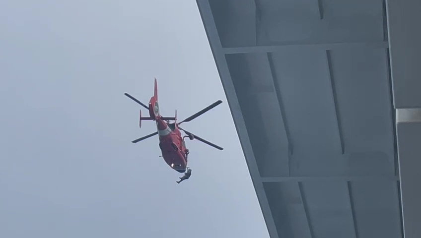a red helicopter is flying over a building