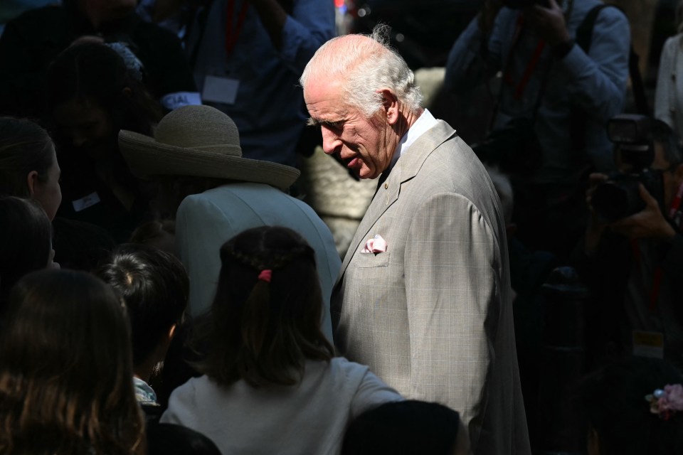 a man in a suit stands in a crowd with a woman wearing a lanyard that says jal