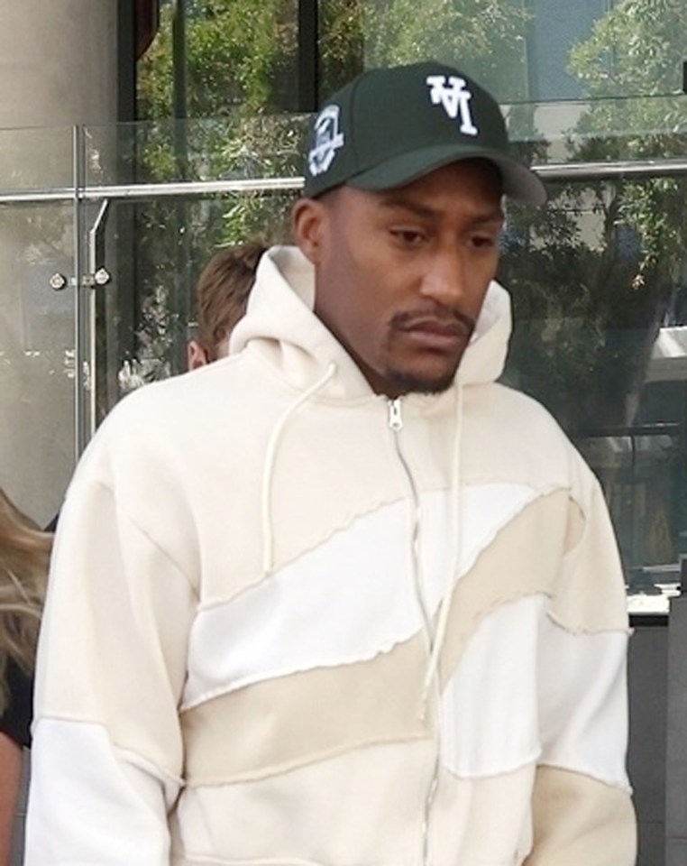 a man wearing a la hat and a hoodie