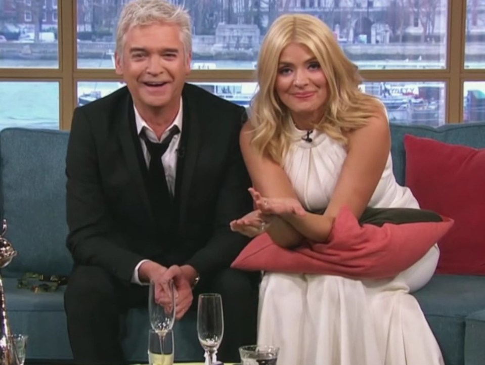 a man and a woman sit on a couch in front of a screen that says this morning