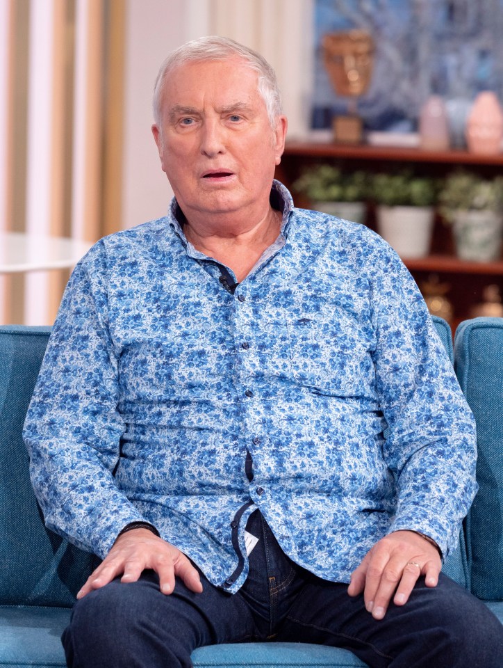 a man in a blue shirt sits on a blue couch