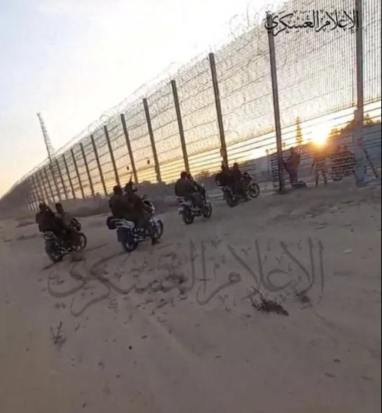 a group of people riding motorcycles in front of a barbed wire fence