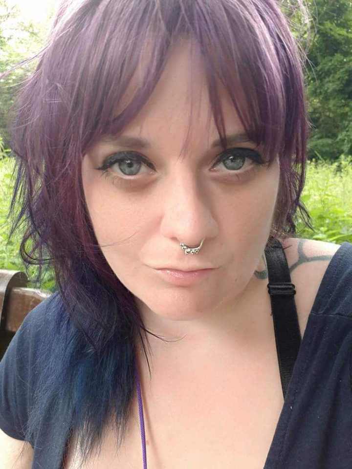 a woman with purple hair and a nose ring