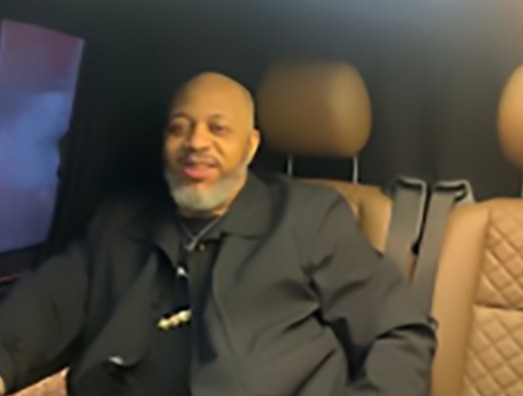 a man in a suit sits in the back seat of a car
