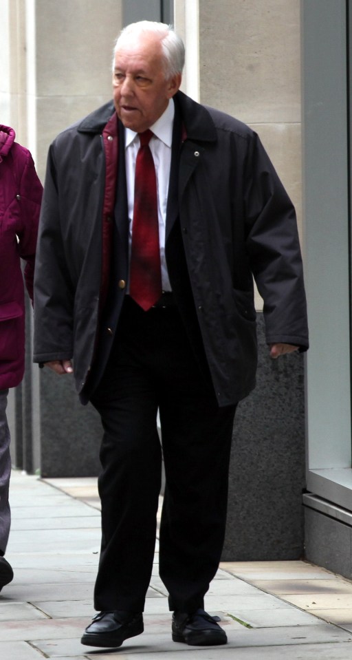 a man in a suit and tie is walking down a sidewalk