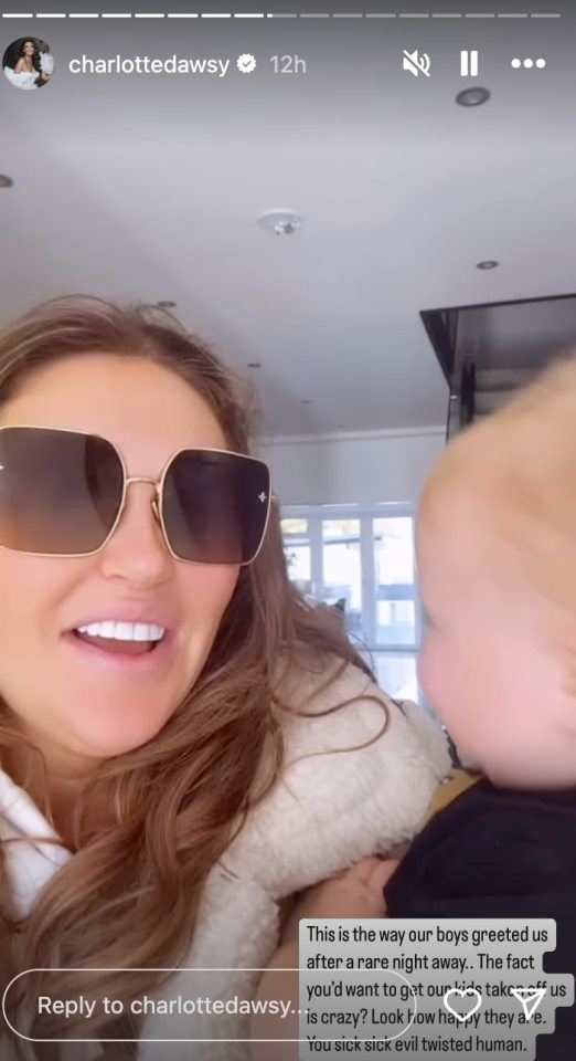 a woman wearing sunglasses is holding a baby in her arms