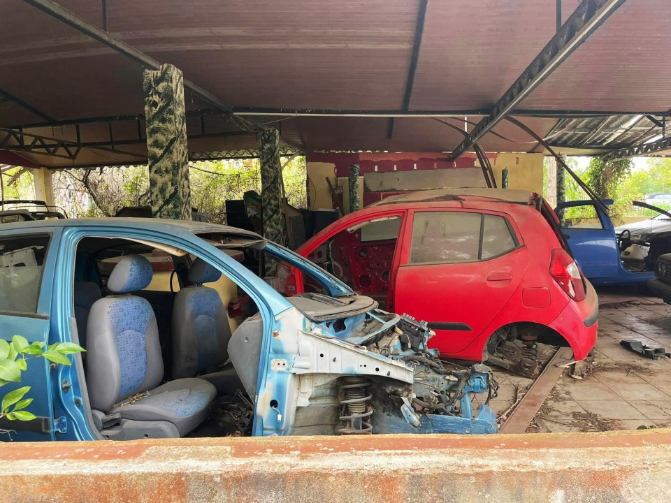 a red car is being dismantled in a garage