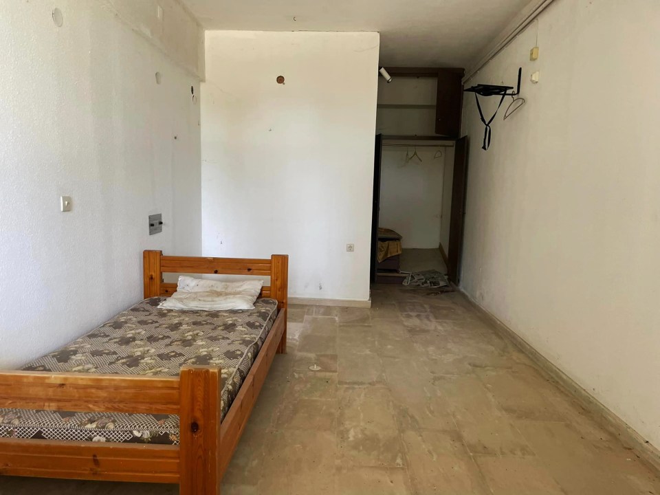 a small bedroom with a wooden bed and a mattress