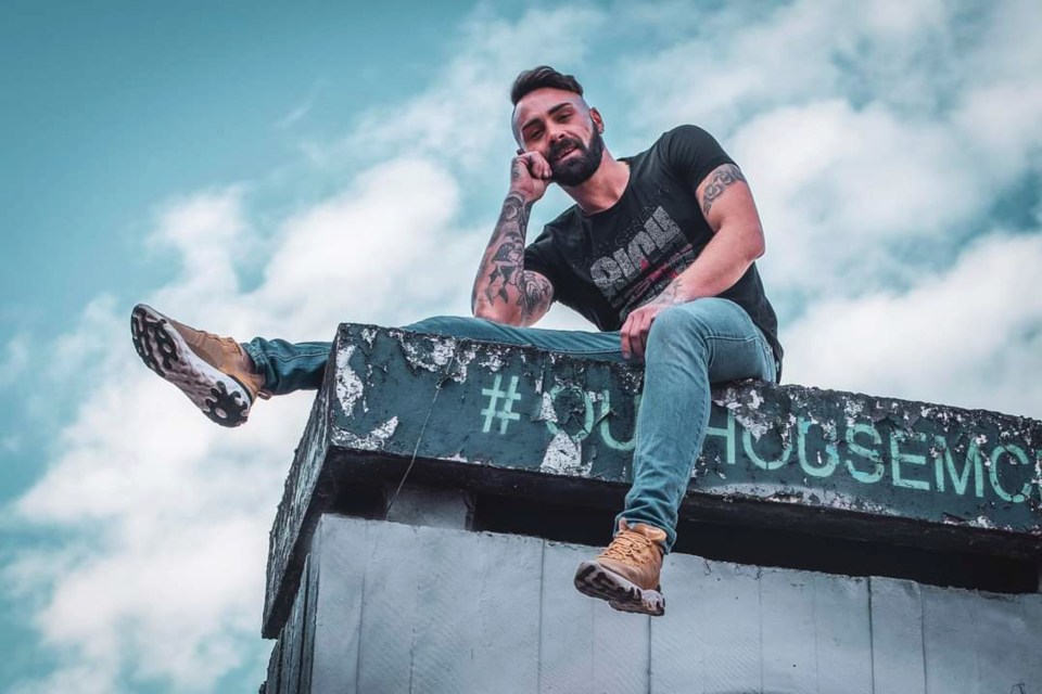 a man sitting on top of a concrete block that says hogsemc