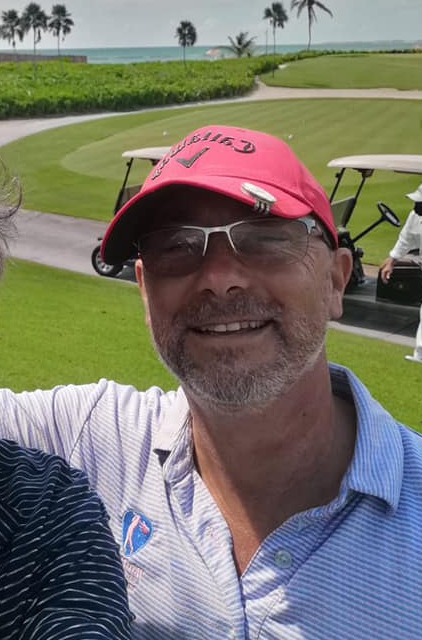 a man wearing a red hat and sunglasses is smiling on a golf course