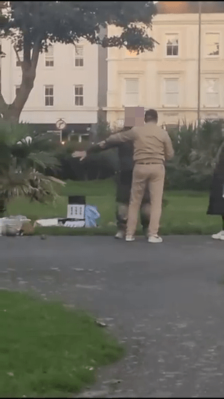 two men are standing next to each other in a park .