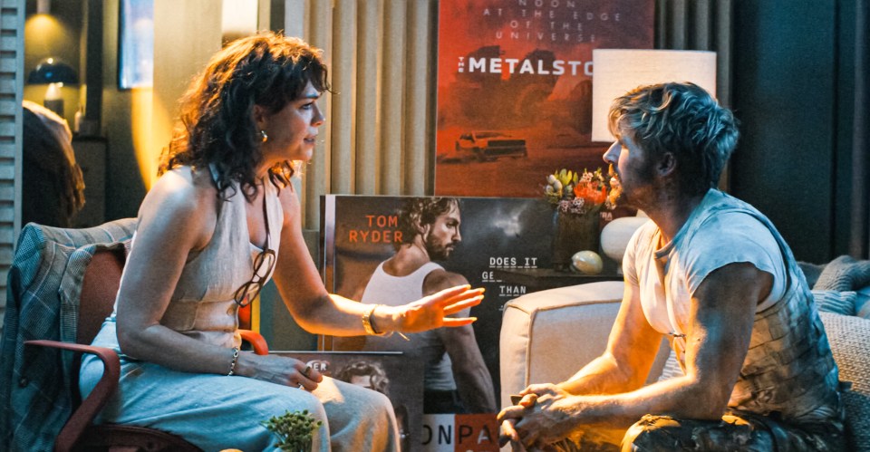 a man and a woman sit in front of a metalsto poster