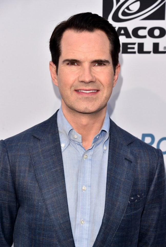 a man in a suit stands in front of a taco bell logo