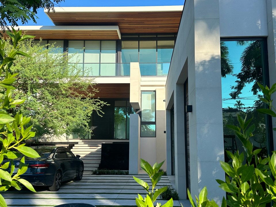 a black car is parked in front of a modern house