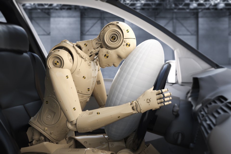 a robot is sitting in a car with an air bag