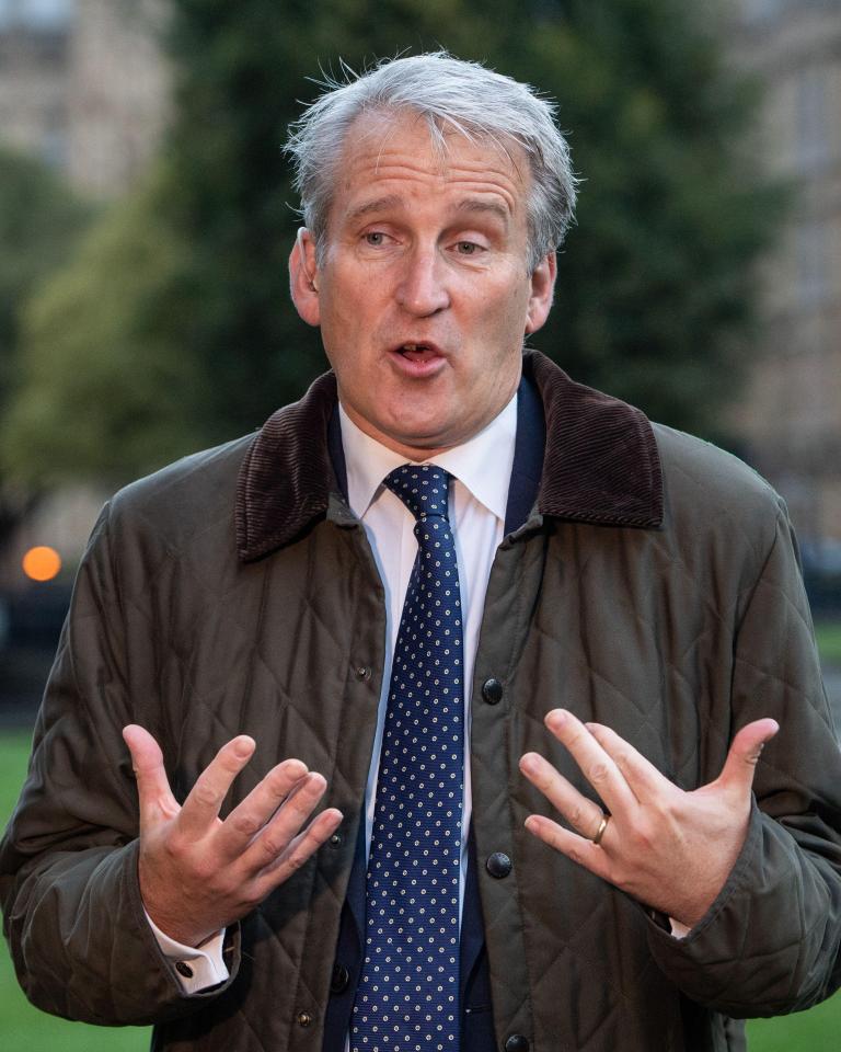 a man wearing a jacket and tie is talking